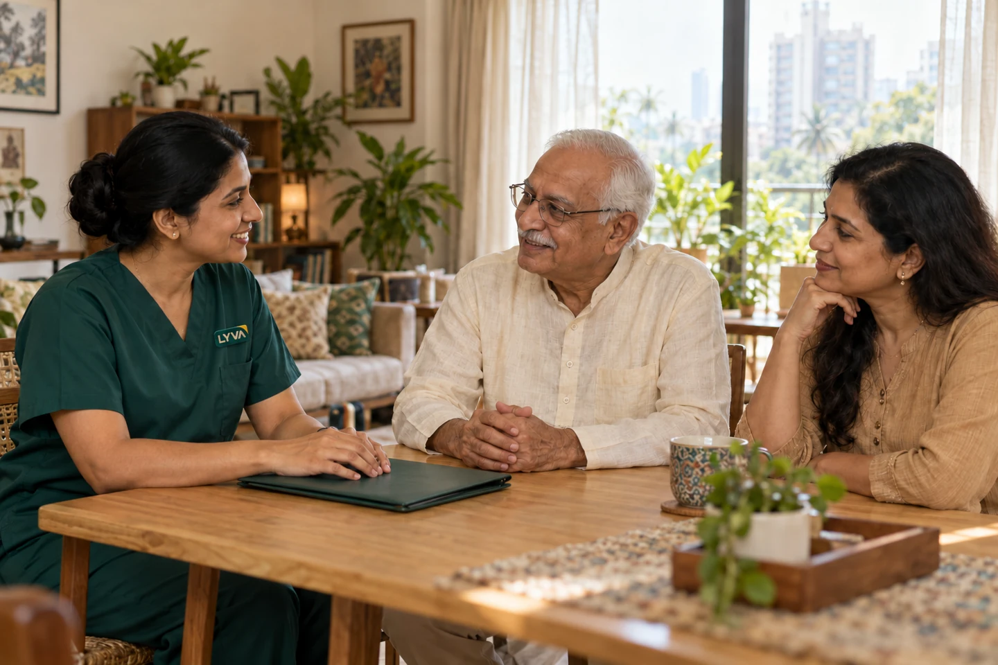 A LYVA-branded nurse talking with an older man and his daughter at home